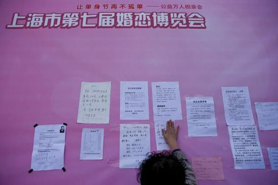 10月31日，罗店镇艾玛宫婚礼公园，一位家长将写好的子女征婚信息贴在”寻缘墙“上。