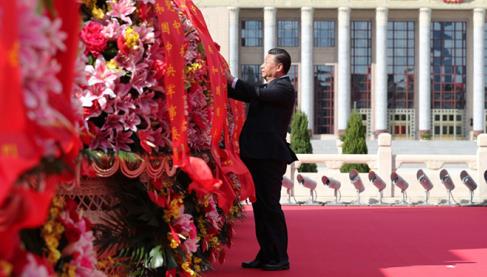 9月30日上午，习近平等党和国家领导人来到北京天安门广场，出席烈士纪念日向人民英雄敬献花篮仪式。这是习近平整理花篮上的缎带。图片来源：新华社